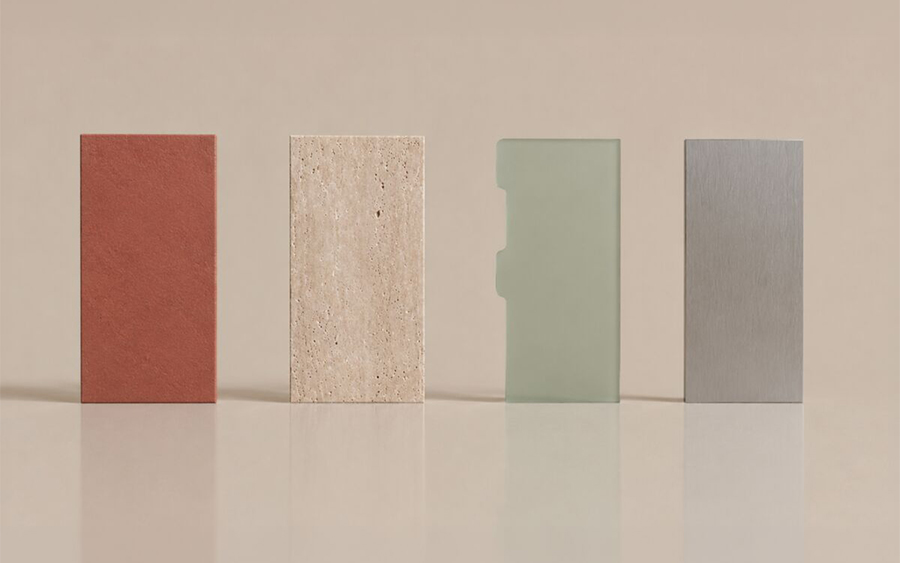 I quattro piani del trofeo Isola Design Awards 2026 in fila: rosso opaco, sabbia porosa, verde traslucido con tacca e metallo spazzolato